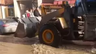 Переправка людей через улицу в ковше погрузчика попала на видео в затопленной Караганде