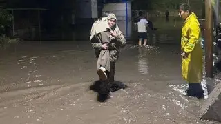 Спасатель на руках носил девушек через лужи в Алматы: фото